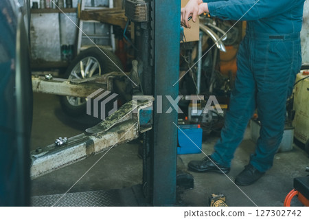 操作雙柱舉昇機的汽車修理工 127302742
