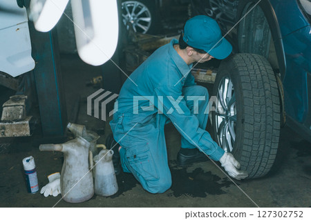 Automobile mechanic exchanging tires Automobile mechanic exchanging tires 127302752