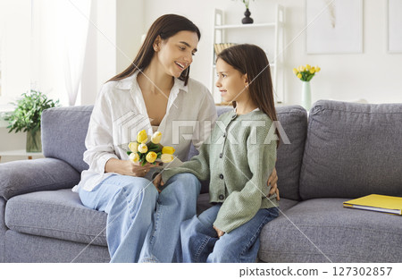 Happy Mother's Day holiday, mother and daughter, girl in living room at home, smiling loving mom 127302857