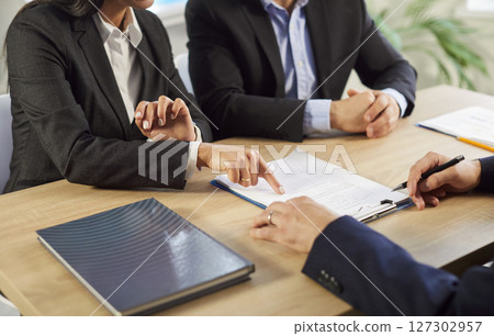 Business clients pointing at a mistake in a contract agreement on the office table 127302957