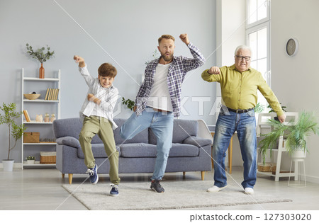 Happy multi generation family of men having fun in living room, dancing and enjoying time together. 127303020