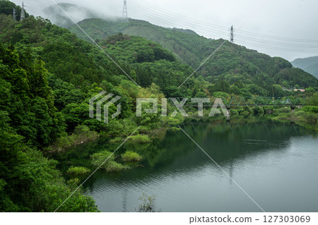 A misty landscape of Lake Kusaki and the railway bridge, with fresh greenery 127303069