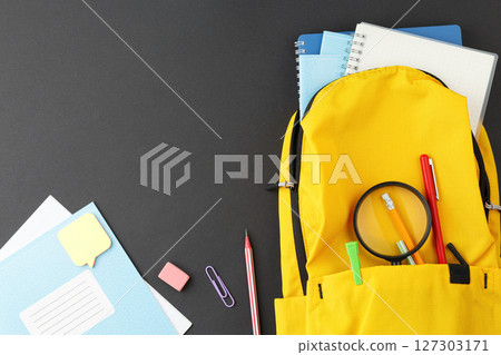 School supplies in a yellow backpack. School supplies in a yellow backpack. 127303171
