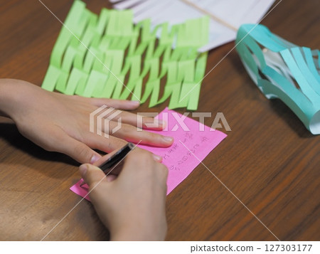 Children writing their wishes on strips of paper 127303177