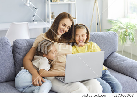 Happy family time, smiling kids, happy mom enjoying leisure at home together, using laptop Happy family time, smiling kids, happy mom enjoying leisure at home together, using laptop 127303308