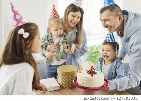 Happy joyful family sitting at home together congratulating their little child girl with birthday 127303336