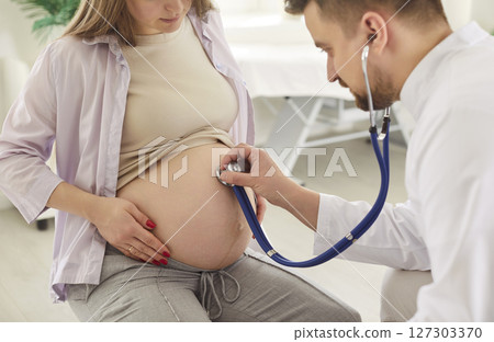 Young pregnant woman checkups visiting doctor in clinic, medical gynecologist examines heartbeat 127303370
