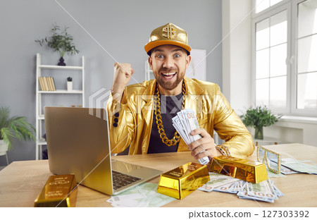 Funny excited man sitting at desk holding money cash of dollar bills celebrating success. Funny excited man sitting at desk holding money cash of dollar bills celebrating success. 127303392