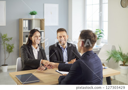 Businessman Shaking Hands With Colleague Or Client In Office Setting Businessman Shaking Hands With Colleague Or Client In Office Setting 127303429