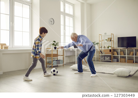 Grandfather And Grandson Playing Football Together At Home 127303449