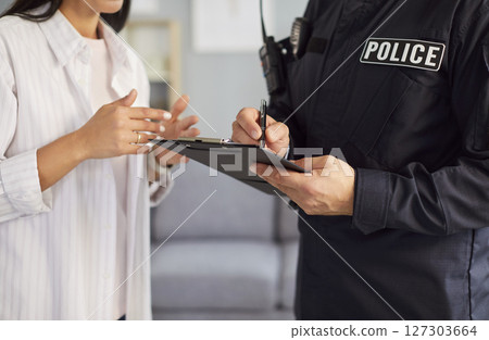 Police Officer Writing Report At Crime Scene For Investigation Police Officer Writing Report At Crime Scene For Investigation 127303664