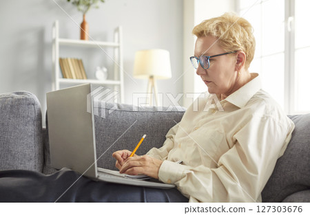 Elderly Woman Working Online With Laptop And Documents Elderly Woman Working Online With Laptop And Documents 127303676