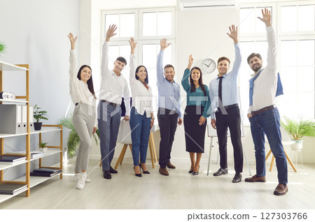 Group Portrait Of Happy Office Team Celebrating Success And Raising Hands 127303766