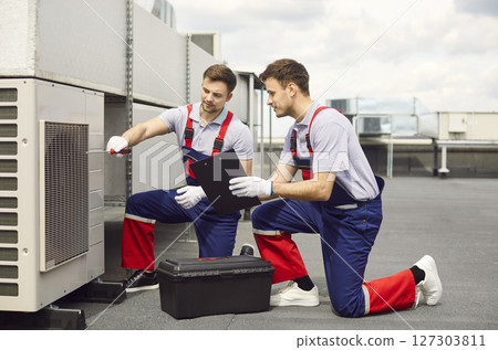 Engineers And Electricians Installing Or Repairing Air Conditioners On A Roof 127303811