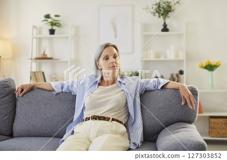 Portrait Of Happy Elderly Woman Resting On Sofa At Home Portrait Of Happy Elderly Woman Resting On Sofa At Home 127303852