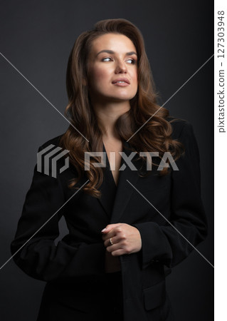 Beautiful woman with dark suit and wavy hair studio portrait Beautiful woman with dark suit and wavy hair studio portrait 127303948