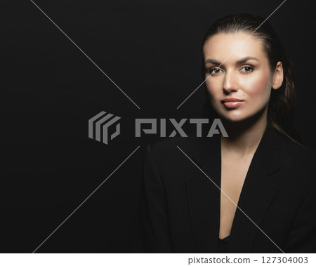 Beautiful woman with dark suit and wet hair studio portrait 127304003