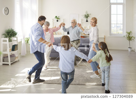 Three happy generations family common funny dance at home in new living room, congratulating Three happy generations family common funny dance at home in new living room, congratulating 127304089