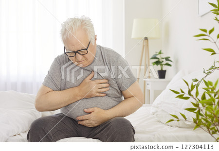 Senior Man Experiencing Health Issue Or Heart Pain At Home 127304113