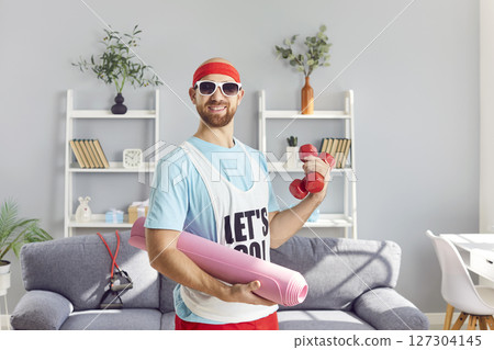 Funny energetic active sportsman with mat, dumbbells training strong muscle building, playful  127304145