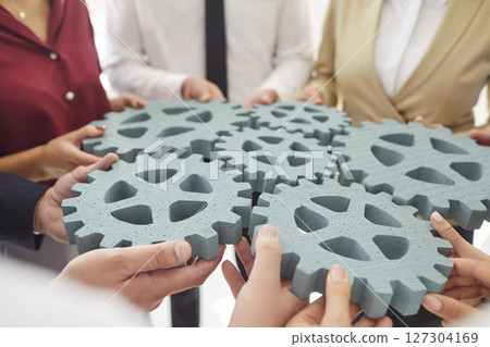 Group of business people connecting gears together. Cooperation and teamwork concept. 127304169