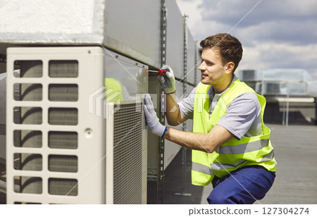 Repairman Fixing Hvac System On Roof 127304274