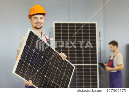 Smiling Worker Holding Solar Panel In Store Smiling Worker Holding Solar Panel In Store 127304275