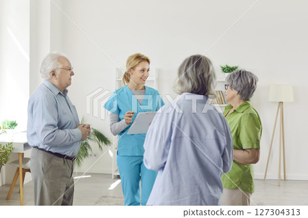 Elderly people listening young woman nurse or psychologist talking with seniors in nursing home. Elderly people listening young woman nurse or psychologist talking with seniors in nursing home. 127304313