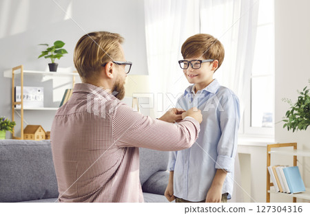 Caring Dad Buttoning Up Son Shirt with Love Caring Dad Buttoning Up Son Shirt with Love 127304316