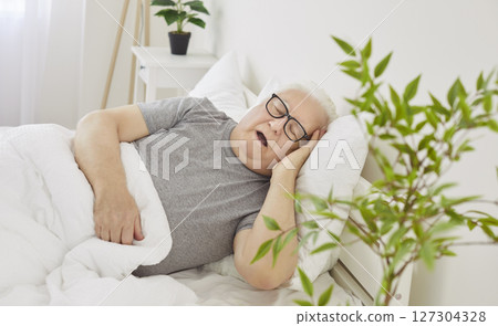 Senior Man Sleeping In Bed Early In The Morning In His Bedroom At Home Senior Man Sleeping In Bed Early In The Morning In His Bedroom At Home 127304328