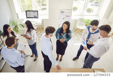 Group of young confident business people men and women talking in office during a meeting. Group of young confident business people men and women talking in office during a meeting. 127304333