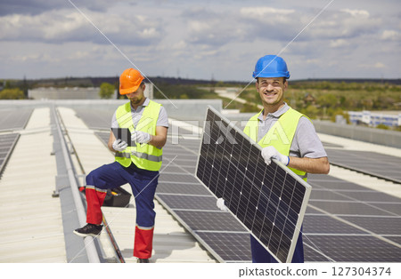 Portrait of Worker Holding Solar Panel During Roof Installation Portrait of Worker Holding Solar Panel During Roof Installation 127304374