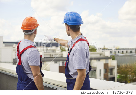 Builders Planning Construction Site on Rooftop Builders Planning Construction Site on Rooftop 127304378