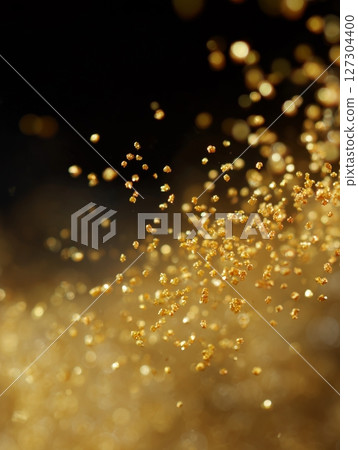 Golden particles and light bokeh dancing on a black background 127304400