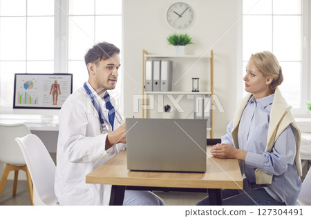 Male smiling young doctor consulting, health insurance deal with elderly patient at consultation Male smiling young doctor consulting, health insurance deal with elderly patient at consultation 127304491