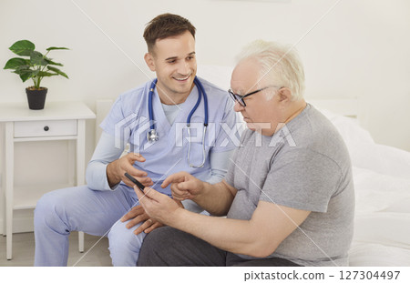 Young physician and senior patient using health care application on mobile phone Young physician and senior patient using health care application on mobile phone 127304497