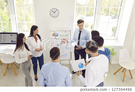 Business coach speaker in office gives presentation, male speaker presenter consulting, training Business coach speaker in office gives presentation, male speaker presenter consulting, training 127304498