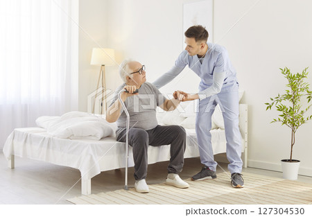 Nursing senior aged man at home, supporting young doctor, nurse taking care of old patient check  127304530