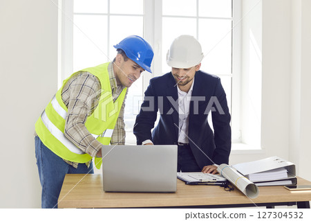 Engineer colleagues meeting looking at project online, blueprints, planning work, renovation Engineer colleagues meeting looking at project online, blueprints, planning work, renovation 127304532