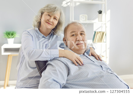 Happy senior family couple wife and husband sitting on sofa in the living room at home. Happy senior family couple wife and husband sitting on sofa in the living room at home. 127304555