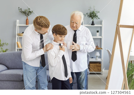 Happy multi generation family of men wearing white shirts and ties preparing for special occasion. Happy multi generation family of men wearing white shirts and ties preparing for special occasion. 127304561