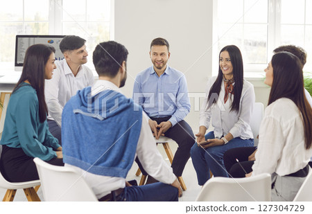 A group of business people are sitting in a circle in the office 127304729
