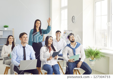 Office Worker Raising Hand To Ask Question During Office Meeting Or Presentation 127304733