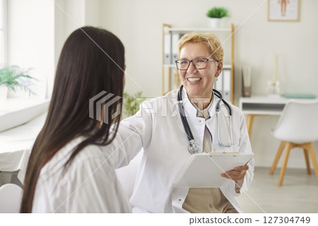 Senior Doctor Or Nurse Communicating With Patient During Appointment At Clinic 127304749