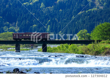 A local train crossing the No. 2 Yatokawa Bridge on an early summer morning when the water is melting from the snow. 127304812