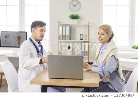 Woman having an appointment with a doctor and looking at medical test results on a laptop Woman having an appointment with a doctor and looking at medical test results on a laptop 127304984