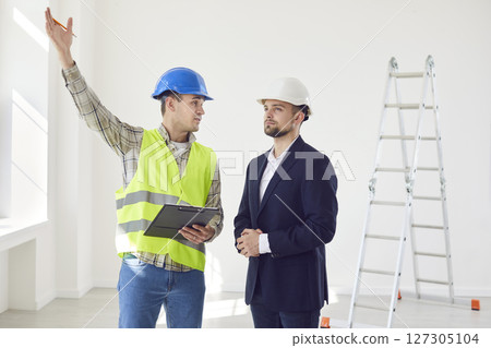 Foreman discussing with young architect design project or repair of new apartment Foreman discussing with young architect design project or repair of new apartment 127305104