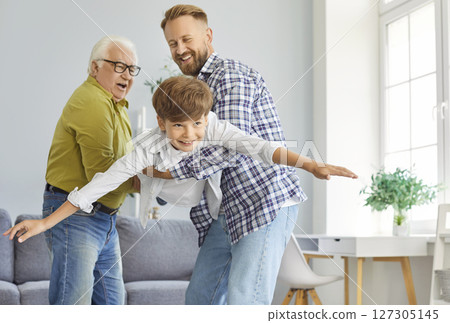Funny playful family of three generation men, senior grandfather, adult father, grandson playing 127305145