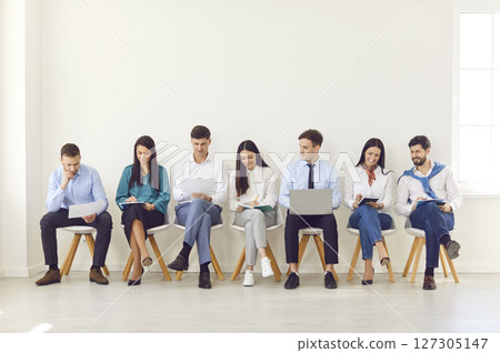 Happy different business people sitting on office chairs in row line, smiling diverse job seekers 127305147