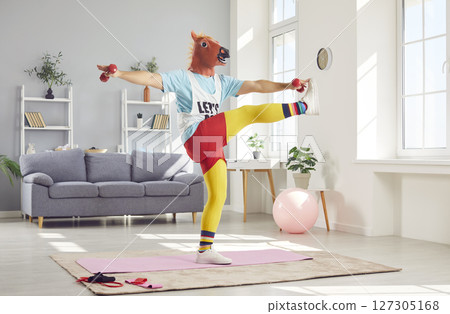Funny Man In Retro Sportswear And Amusing Horse Mask Exercising At Home 127305168